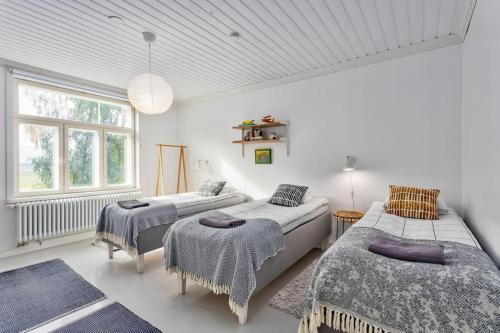 um quarto com 2 camas e uma janela em Villa Degerby - 330m2 Lux Manor w/Heated Pool, Spa em Degerby