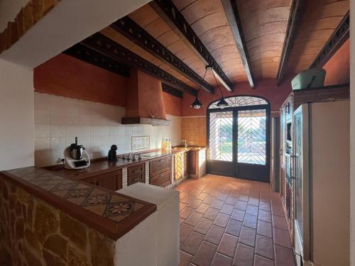 a large kitchen with a counter and a window at La Estacada in Lora del Río