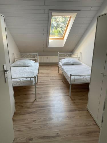 twee bedden in een kamer met een raam bij Kopp in Lohfelden
