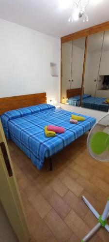 um quarto com uma cama com lençóis azuis e um espelho em Casa Mia em Poggio Moiano