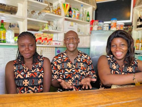 a man and two women standing behind a counter at Auberge Africa Thiossane in Saly Portudal