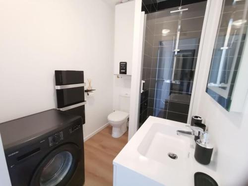 a bathroom with a washing machine and a sink at LE MEDITERRANEEN *T2 (40m²) *WIFI*PARKING PRIVE* in Lourdes