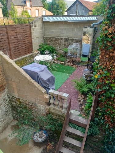 a backyard with a garden with a table and a fence at Sept-Forges Gite in Sept-Forges