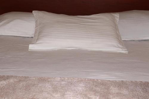 uma cama não feita com lençóis e almofadas brancas em RL Hotel em Stepanavan
