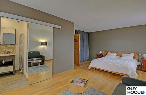 une chambre avec un lit et un salon dans l'établissement Le Moulin du Chardonnet, à Tramolé