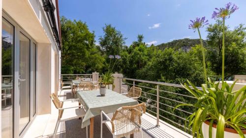 a patio with a table and chairs on a balcony at Scardona Park Luxury Accommodation in Skradin