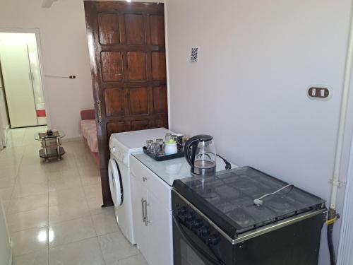 a kitchen with a stove and a washing machine at Sweet Home Flat 1 in Hurghada