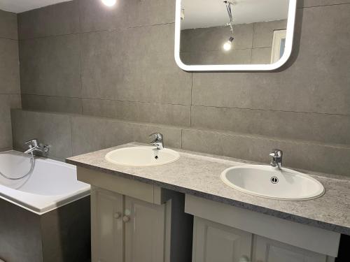 a bathroom with two sinks and a mirror at Uccle Chic Flat in Brussels