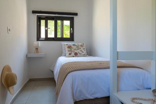 Habitación pequeña con cama y ventana en Fragma suite, en Faneroméni