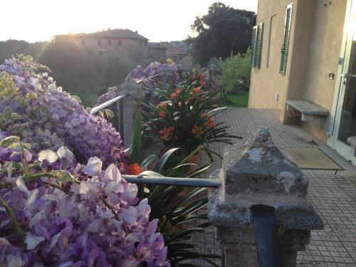 a garden with purple flowers next to a building at Hotel Palazzo di Valli in Siena