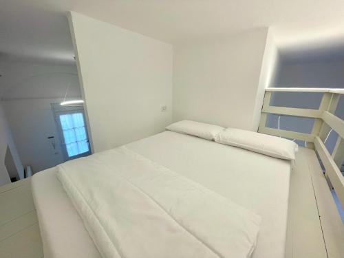 a white bedroom with a bunk bed and a ladder at Casa Manzoni LOFT MXP Town Center in Gallarate
