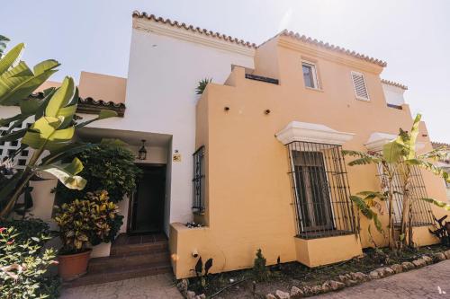 una casa amarilla y blanca con plantas delante en Luxury sea views Townhouse Marbella, en Marbella