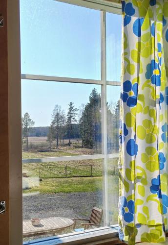 a window with a view of a field at Maalaistalon päätyhuoneisto Merikarvialla in Tuorila