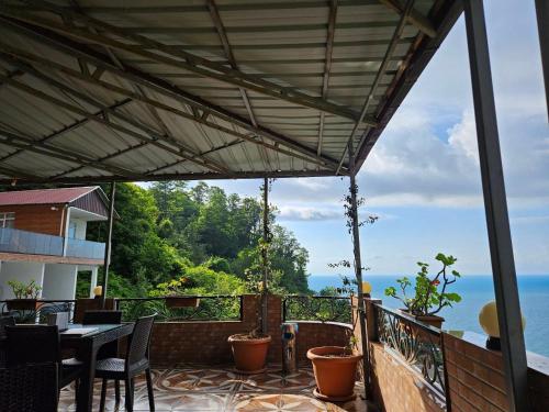 un patio con mesa y sillas y vistas al océano en Goga Guest House en Kvariati