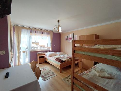 Cette chambre comprend 2 lits superposés et une table. dans l'établissement u Marii Gał, à Leśnica