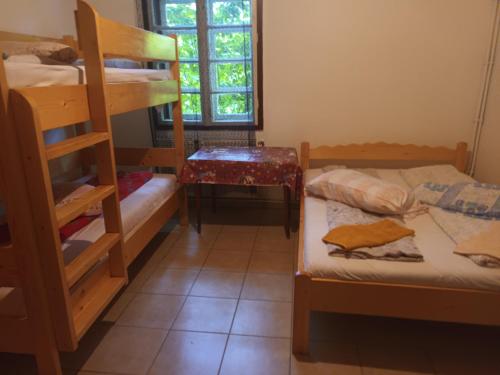 Cette chambre comprend 2 lits superposés et une table. dans l'établissement Antonia, à Băile Tuşnad