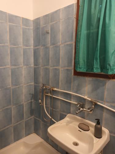 La salle de bains est pourvue d'un lavabo et d'un rideau de douche vert. dans l'établissement Antonia, à Băile Tuşnad
