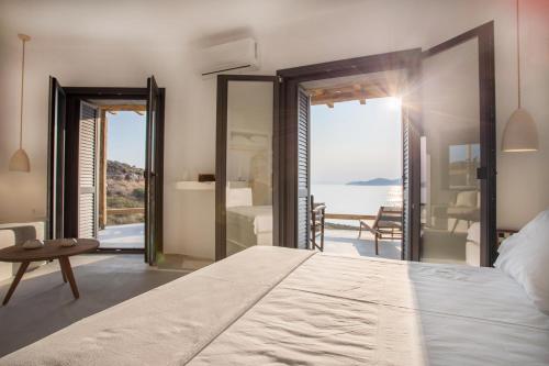 a bedroom with a bed and a view of the ocean at MYRTOS in Karistos