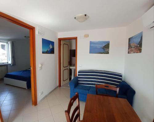 a living room with a blue couch and a table at Blasu Home in Maratea