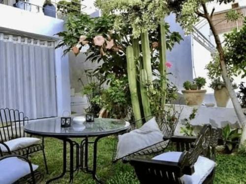 a patio with a table and chairs and plants at Sunsets at Fully Equipped Big APT at the Beach in La Marsa