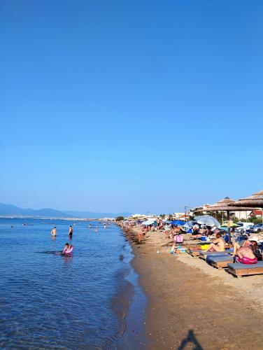 a beach with a lot of people in the water at Antonia's cozy apartment in Agia Triada