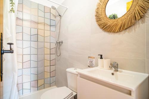 a bathroom with a toilet and a sink and a mirror at Paraje la Suerte Apartamento Crisantemo in Adra