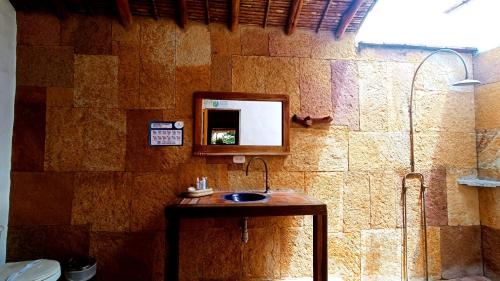 a bathroom with a sink and a mirror on a wall at Hotel Finca Buenos Aires Barichara in Barichara