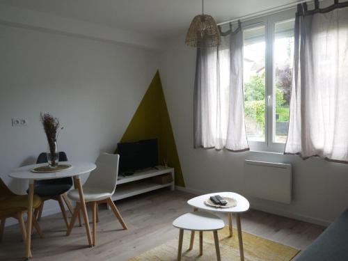 a living room with two tables and a tv at Appartement, Mussidan in Mussidan