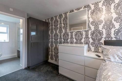 - une chambre avec une commode et un miroir mural dans l'établissement 5 Bedroom 5 Bath sleeps 10 close Luton Airport M1, à Caddington