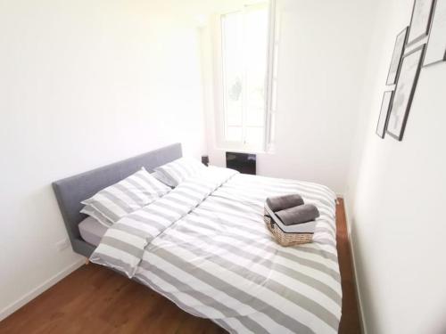 a white bedroom with a bed with a basket on it at LE GOURMAND *T2 (40m²) *WIFI*PARKING PRIVE*CALME in Lourdes