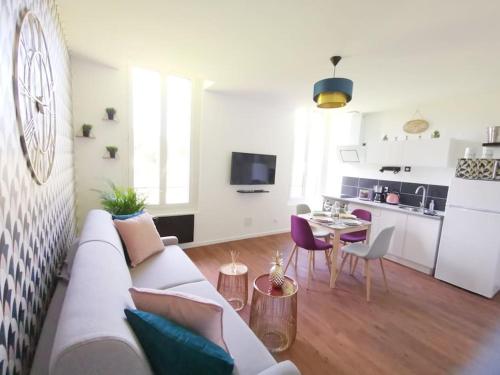 un salon avec un canapé blanc et une cuisine dans l'établissement LE GOURMAND *T2 (40m²) *WIFI*PARKING PRIVE*CALME, à Lourdes