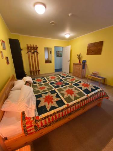 a bedroom with a large bed with a quilt on it at Torgu Royal Guesthouse in Iide