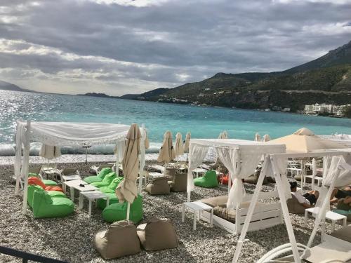 a group of chairs and umbrellas on a beach at Apartment weekend by the sea in Loutraki