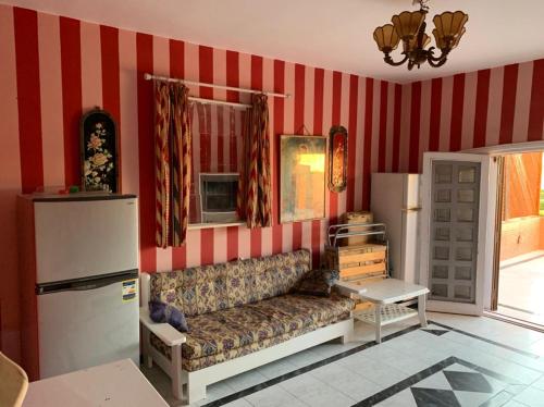a living room with a couch and red striped walls at Marina 2 chalet lake front in El Alamein