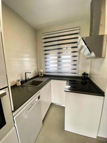 a kitchen with white cabinets and a sink and a window at LOFT VILLALUCIA in Conil de la Frontera