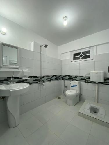Taaj Residence Skardu في سكردو: حمام أبيض مع حوض ومرحاض