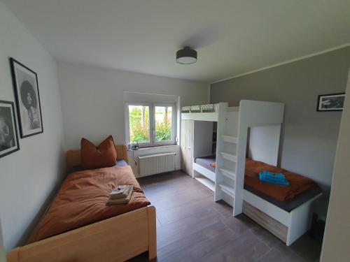 a bedroom with two bunk beds and a window at Neumühler Hof Ferienwohnung "Stefan" bietet 4 Schlafzimmer und 4 Bäder , eine Große Badewanne und großer Terrasse zum Garten, kostenfreie Parkmöglichkeiten in Schwerin