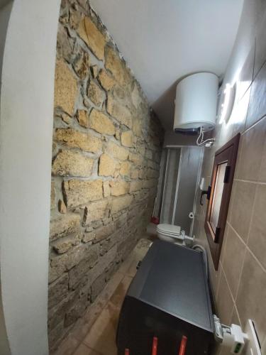 baño con pared de piedra y mesa en La Dimora degli Dei, 