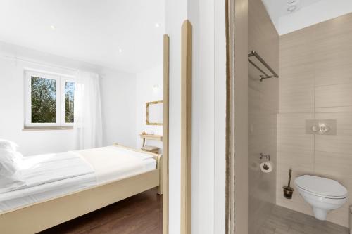 a white bathroom with a bed and a toilet at Kastelir in Kaštelir