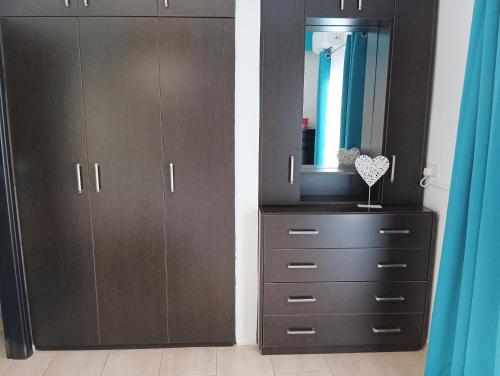 a bedroom with a dresser with a mirror and a cabinet at Rainbow 7th floor penthouse apartment in Engomi