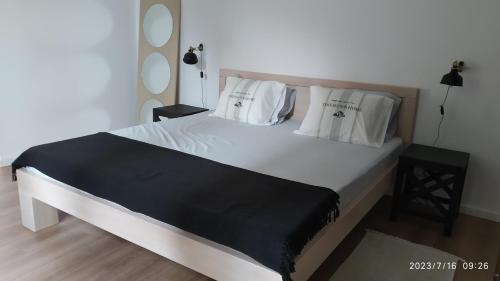 a bedroom with a large white bed with white pillows at Apartman Stara Trešnja in Kladovo