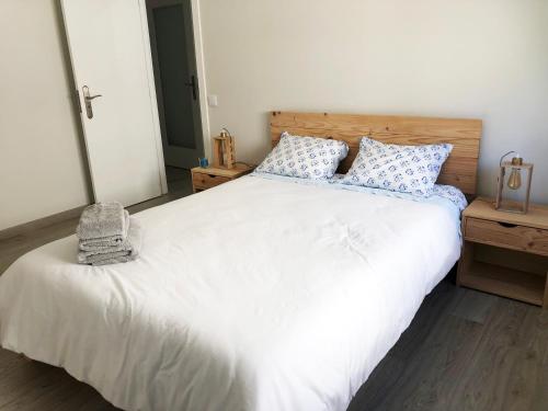 a bedroom with a white bed with blue and white pillows at Market Apartment - VPA in Vila Praia de Âncora