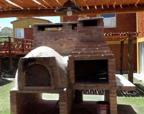 an outdoor brick oven in the yard of a house at Cabañas Gemas del Lago in Potrero de los Funes