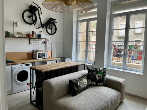 un salon avec un canapé et une table et une cuisine dans l'établissement Charmant T2 en centre ville, à Bourgoin-Jallieu