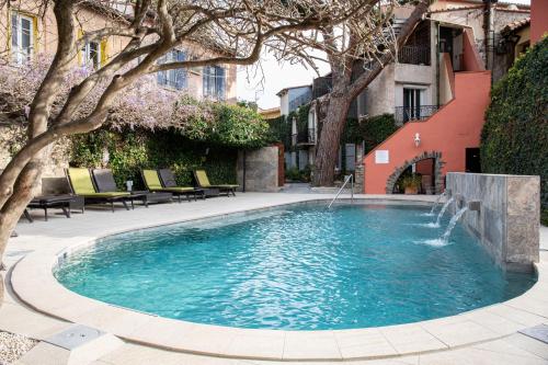 a swimming pool with a fountain in a courtyard at Hôtel La Casa Pairal in Collioure