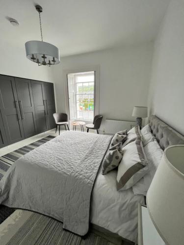 Un dormitorio blanco con una cama grande y una mesa en Bank House, en Inistioge