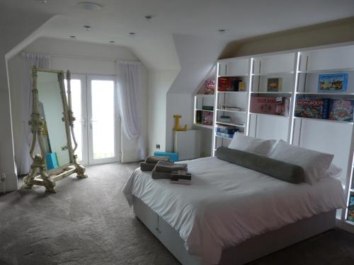 1 dormitorio con 1 cama blanca grande y espejo en Amazing sea views and much more…., en Broadstairs