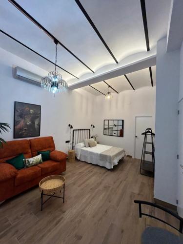 un soggiorno con divano e letto di Apartamentos Casa el Gorras a Cordoba