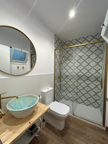 een badkamer met een wastafel, een toilet en een spiegel bij Apartamentos Casa el Gorras in Córdoba