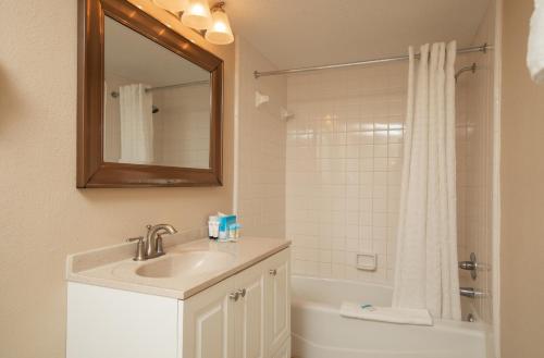 a bathroom with a sink and a shower with a mirror at Grande Shores in Myrtle Beach
